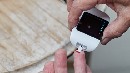 Una persona está utilizando un medidor de glucosa para verificar su nivel de azúcar en la sangre.