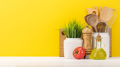 Varios utensilios de cocina y vajilla sobre un fondo amarillo