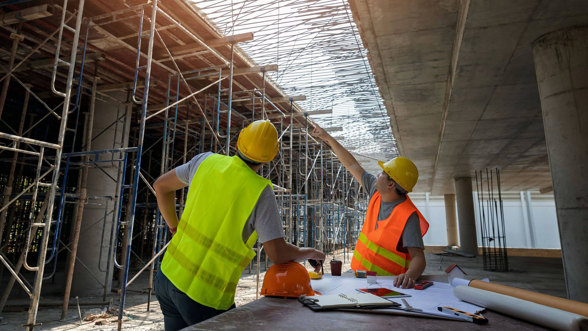 Engineer discussing with foreman about project in building construction site. Engineer and Architect working at Construction Site with blue print